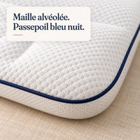 Gros plan sur la maille alvéolée et le passepoil bleu nuit de l’oreiller Nuitalie